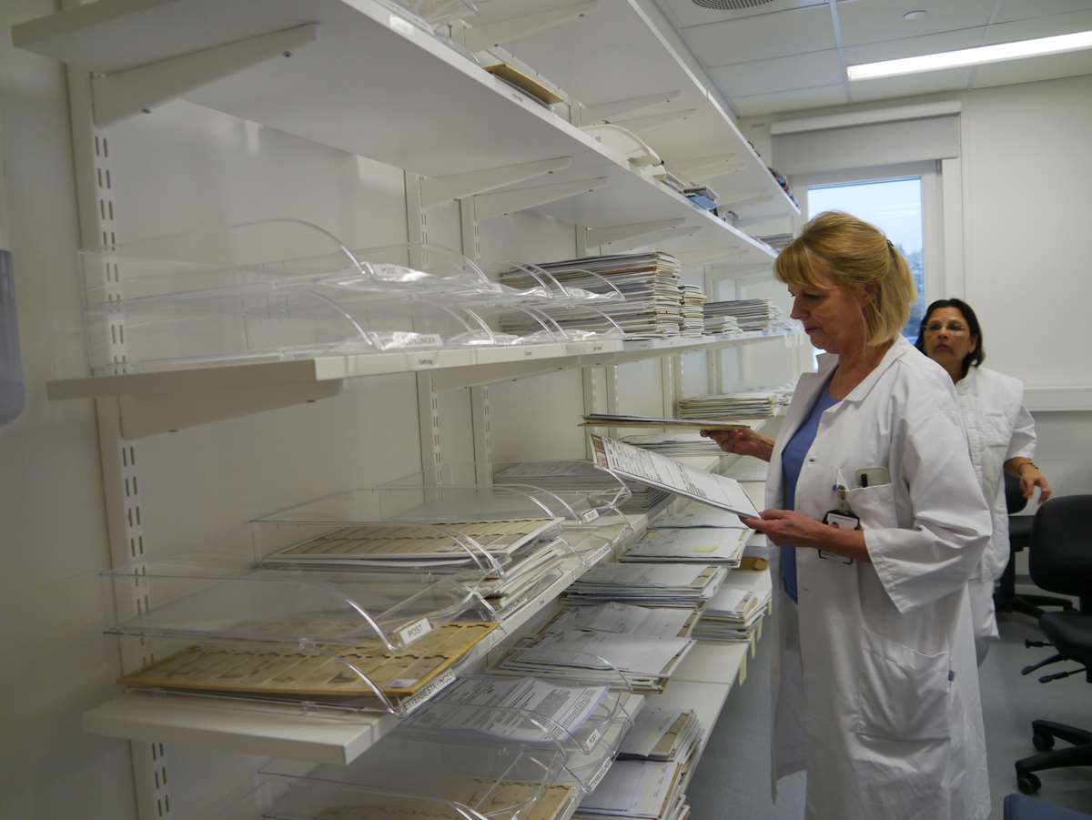 Seksjonsleder Lise-Lotte Gundersen viser fram hyller med hundrevis av ubehandlede patologiprøver.